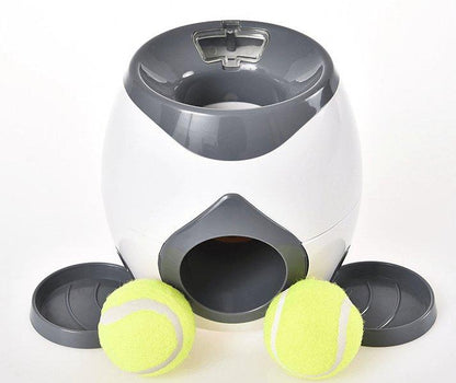 White and gray ball launcher with two yellow tennis balls on a white background