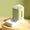 Modern dog water fountain with a geometric design on a gold stand against a green background