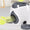 Pet toy dispenser on a surface with tennis balls in the background