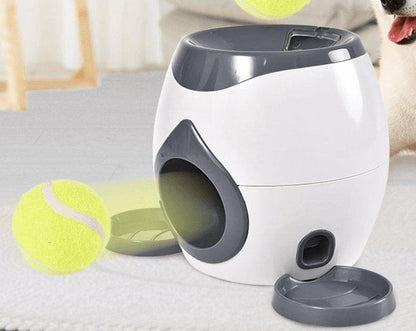 Pet toy dispenser on a surface with tennis balls in the background
