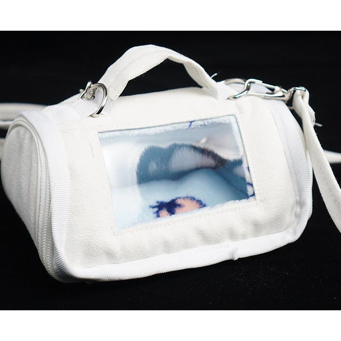 White pet carrier with a transparent window showing a dog inside on a black background