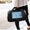 Person holding a black pet carrier with a blue butterfly design on a blurred background