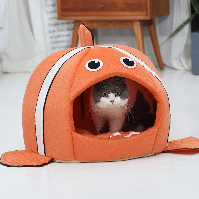 Cat inside an orange fish-shaped pet bed on a light-colored floor.