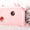 Cat peeking out from a pink pet house on a white background