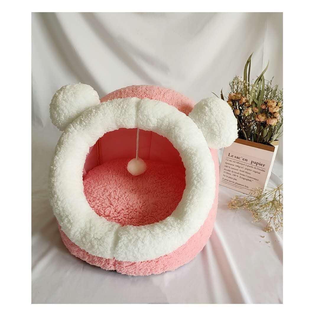 Pink and white pet bed with fluffy texture on a light background