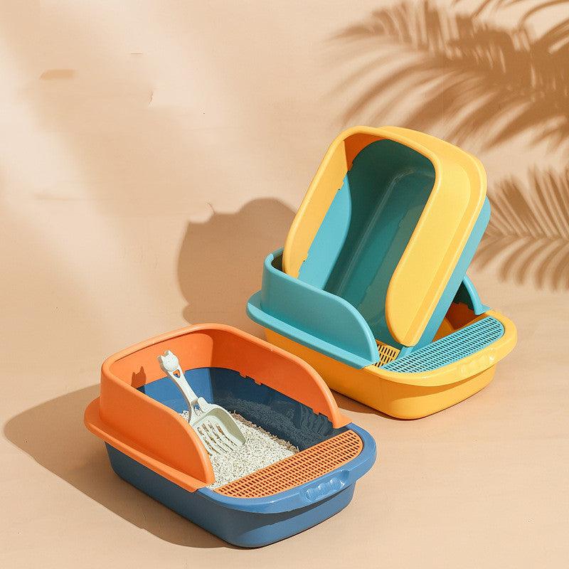Two colorful cat litter boxes with a scoop on a beige background