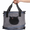 Gray pet carrier with black cat face design held by a hand on a white background