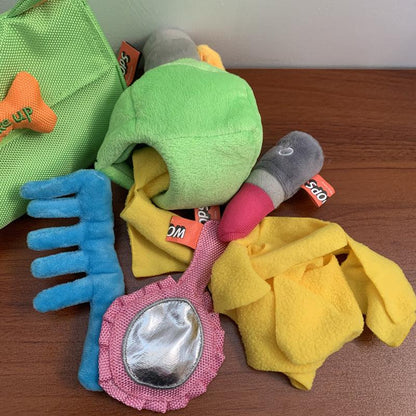 Assorted dog toys including a green plush toy, blue rubber toy, and yellow fabric toy on a wooden surface.
