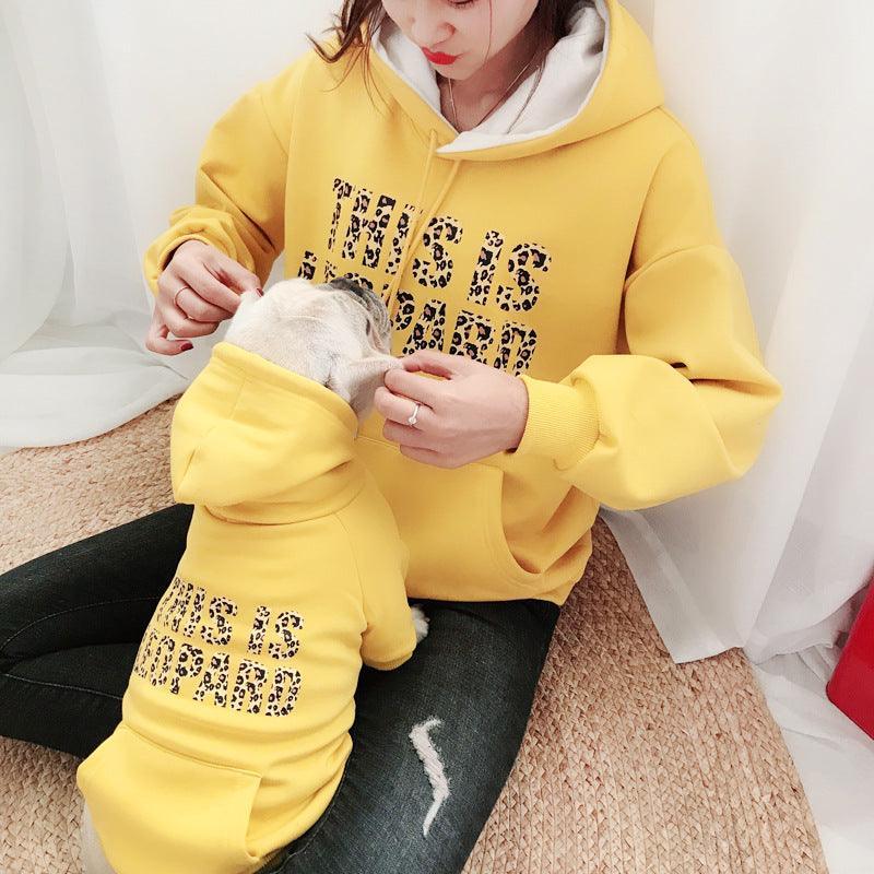 Person wearing a yellow hoodie with text, sitting on a carpeted floor.