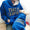 Person wearing a blue hoodie with leopard print text, sitting on a wooden floor.
