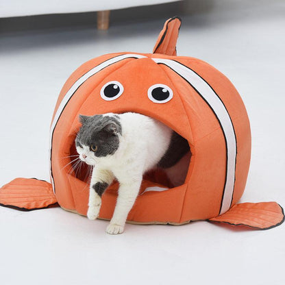 Cat inside a fish-shaped pet bed on a light gray surface