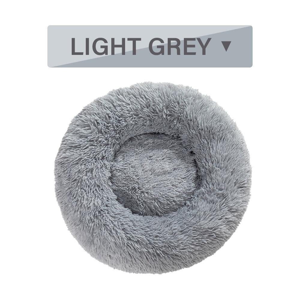 Light gray fluffy pet bed with a label indicating the color on a white background