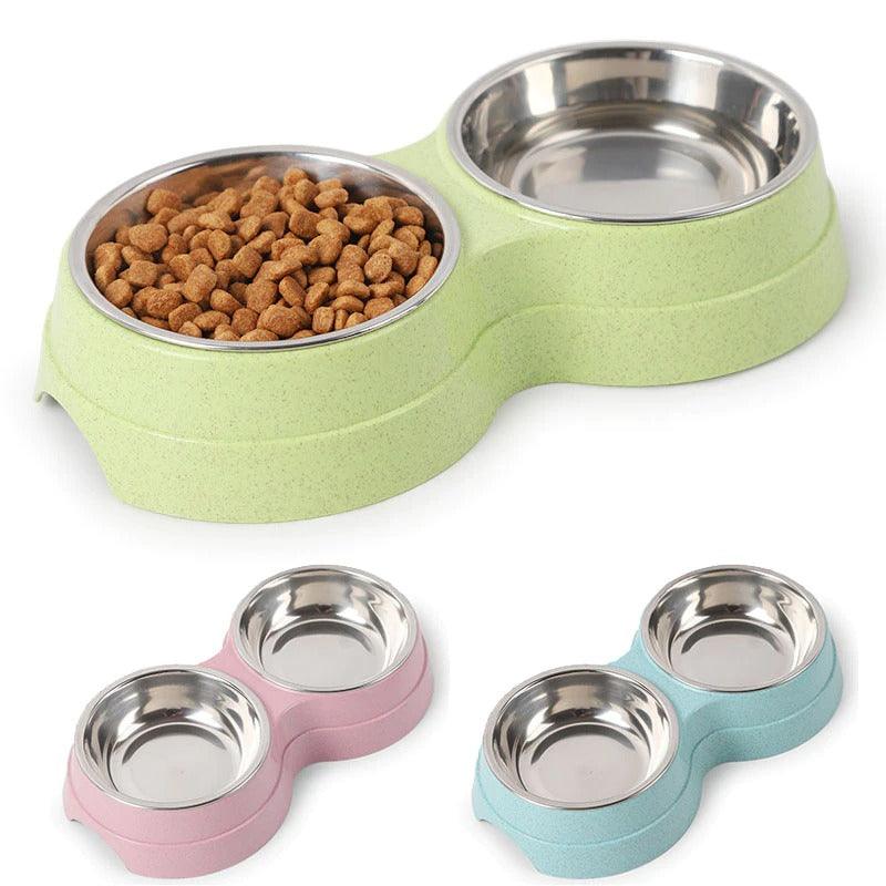 Pet food bowl set with green, pink, and blue bases on a white background